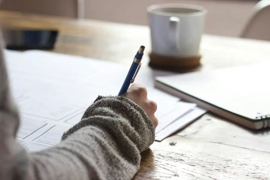 Person writing notes at a desk